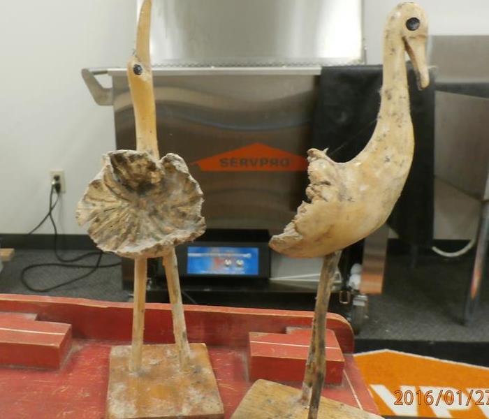 Wooden bird figurine affected by water and mold damage