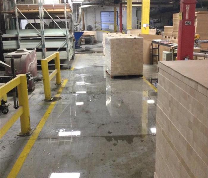image of warehouse with some pallets and equipment and floor flooded