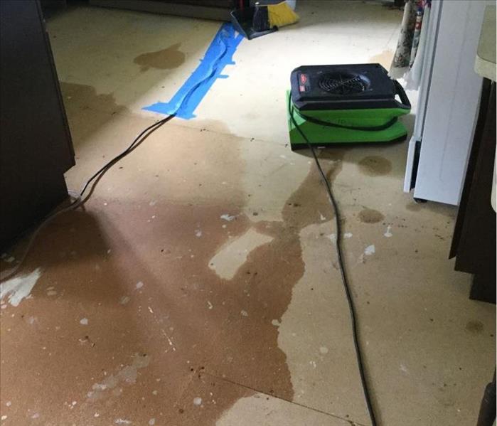 kitchen floor has been removed and you can see water damage. SERVPRO equipment set up to dry. 