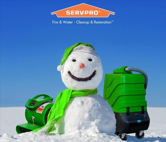 A snowman with a green scarf and hat with SERVPRO equipment on a sunny day
