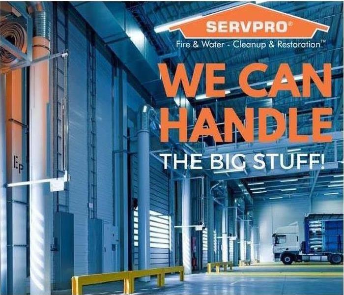 A big warehouse with SERVPRO logo on top and text saying we can handle the big stuff! under
